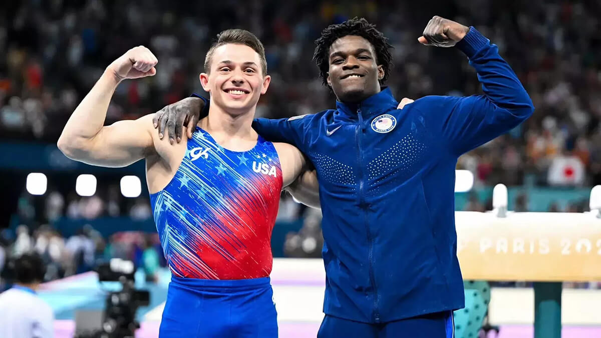 U-M mens' gymnastics athletes flexing their muscles at the Olympics