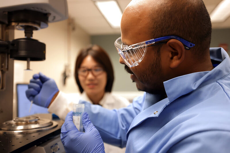 Researchers wearing safety equipment working in a lab