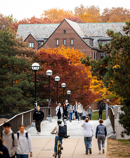 People walking across the bridge between central campus and the Hill dorms