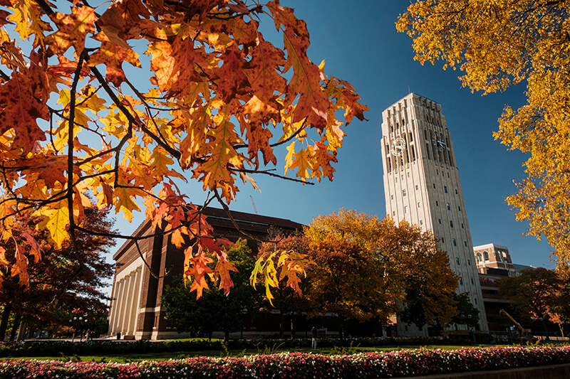 Burton Tower and Hill Auditorium with autumn leaves